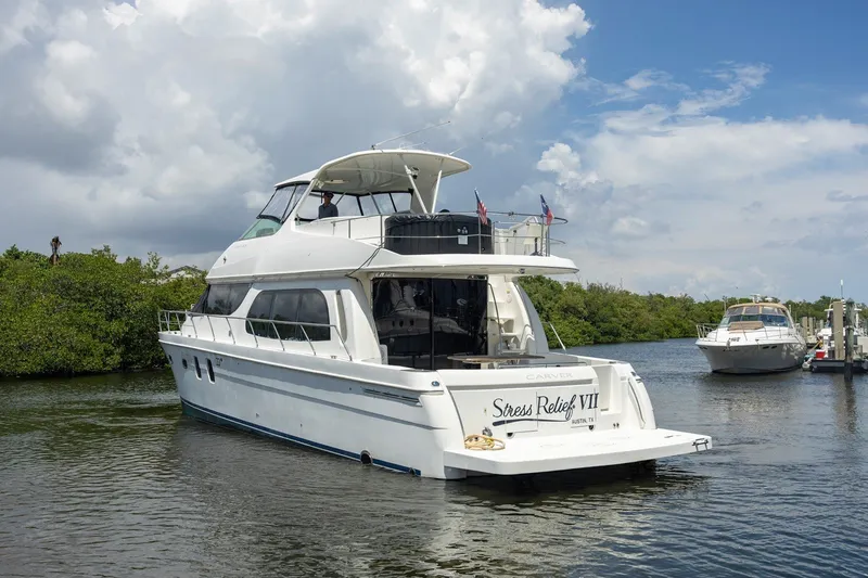Slide: The Image of 2007 Carver 56 Voyager SE yacht on calm water under a partly cloudy sky. - 5