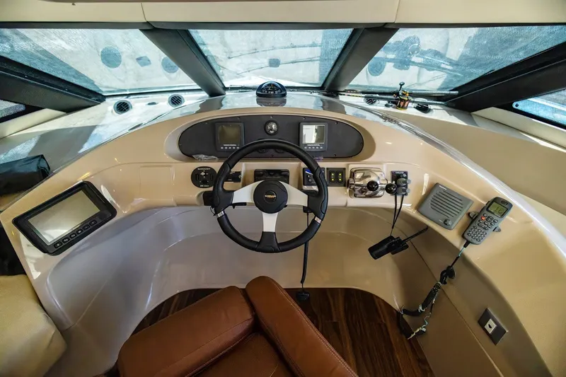 Slide: The Image of 2007 Carver 56 Voyager SE helm with steering wheel, navigation controls, and communication devices. - 19