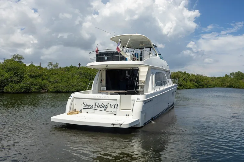 Slide: The Image of 2007 Carver 56 Voyager SE yacht named "Stress Relief VII" on a serene waterway. - 6