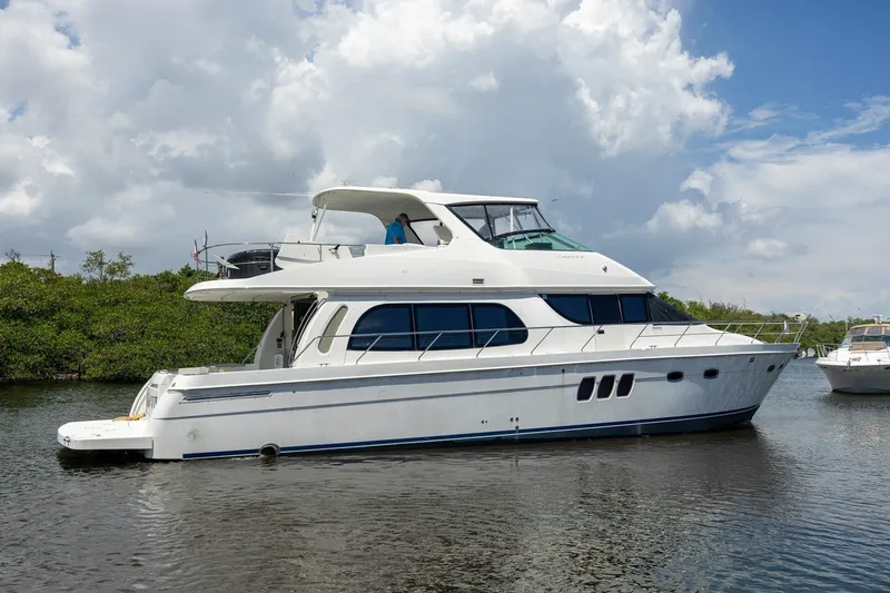 Slide: The Image of 2007 Carver 56 Voyager SE yacht on calm water under a cloudy sky. - 3