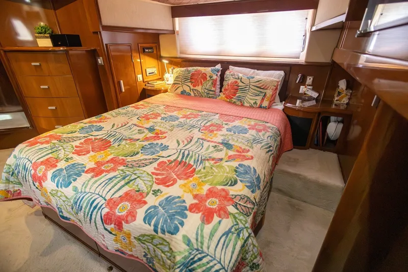 Slide: The Image of Luxurious 2007 Carver 56 Voyager SE bedroom with floral bedding and elegant wood cabinetry. - 28