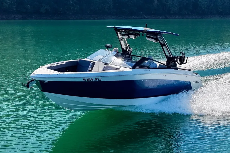 Slide: The Image of 2022 Cobalt R8 Surf boat cruising on clear turquoise water. - 82