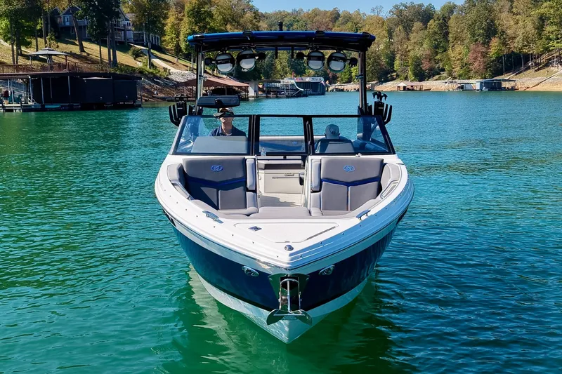 Slide: The Image of 2022 Cobalt R8 Surf boat on a serene lake with lush green surroundings. - 14