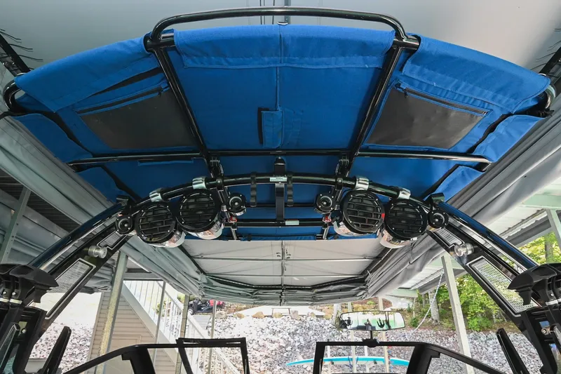 Slide: The Image of 2022 Cobalt R8 Surf boat with blue canopy and mounted speakers. - 14