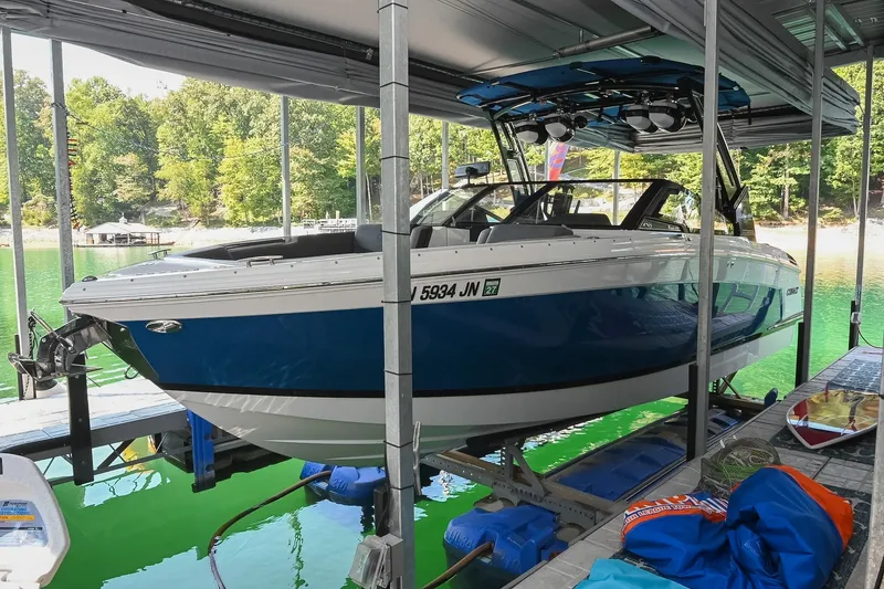 Slide: The Image of 2022 Cobalt R8 Surf boat docked on a lake with lush green surroundings. - 3