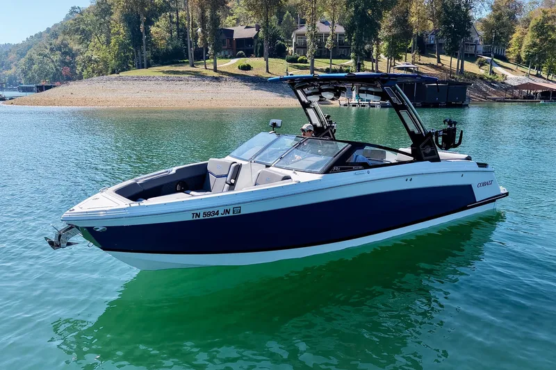 Slide: The Image of 2022 Cobalt R8 Surf boat on a serene lake with lush shoreline. - 16