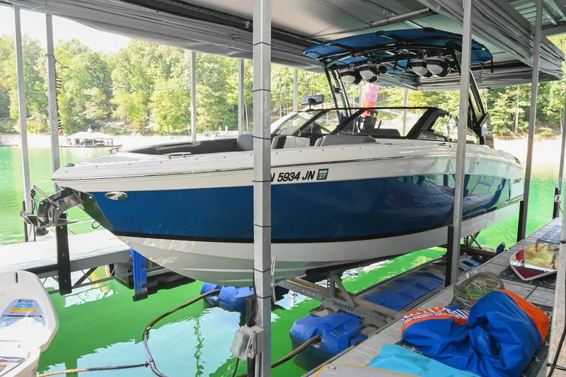 The Image of 2022 Cobalt R8 Surf boat docked on a lift in a scenic lake setting. - 0