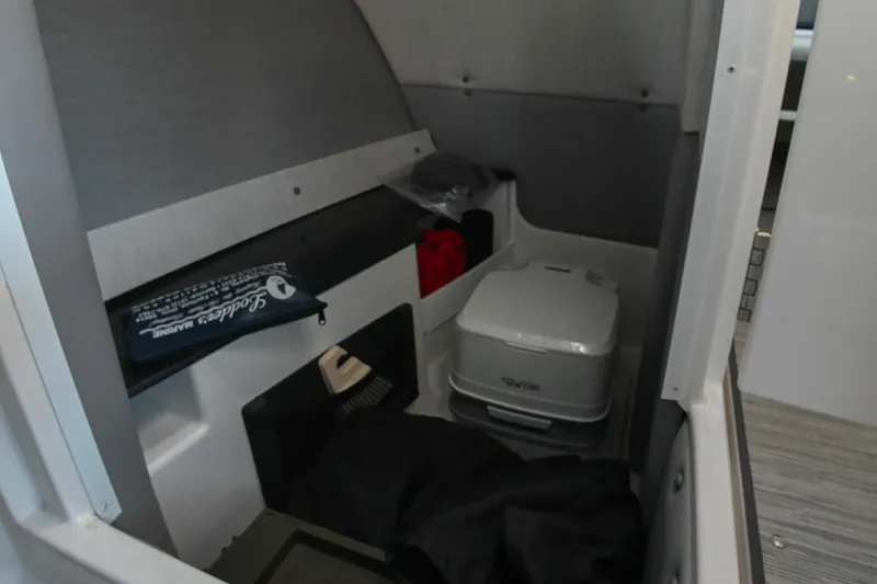 Slide: The Image of Interior storage area of 2022 Cobalt R8 Surf boat with portable toilet. - 31