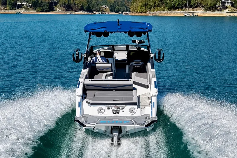 Slide: The Image of 2022 Cobalt R8 Surf boat cruising on a clear blue lake with scenic shoreline. - 20