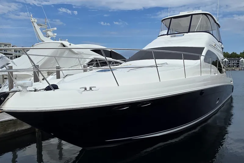 Slide: The Image of 2005 Sea Ray 550 Sedan Bridge yacht docked at marina under clear blue sky. - 6