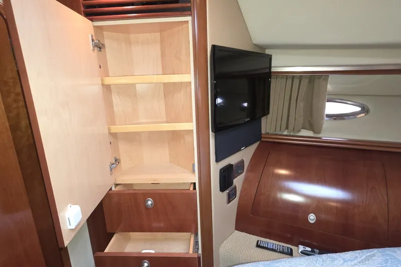 Slide: The Image of Interior of 2005 Sea Ray 550 Sedan Bridge with open cabinet and mounted TV. - 48