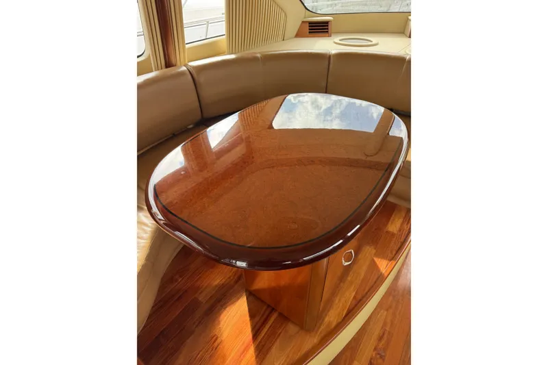 Slide: The Image of Luxurious interior of 2005 Sea Ray 550 Sedan Bridge with polished wooden table. - 35