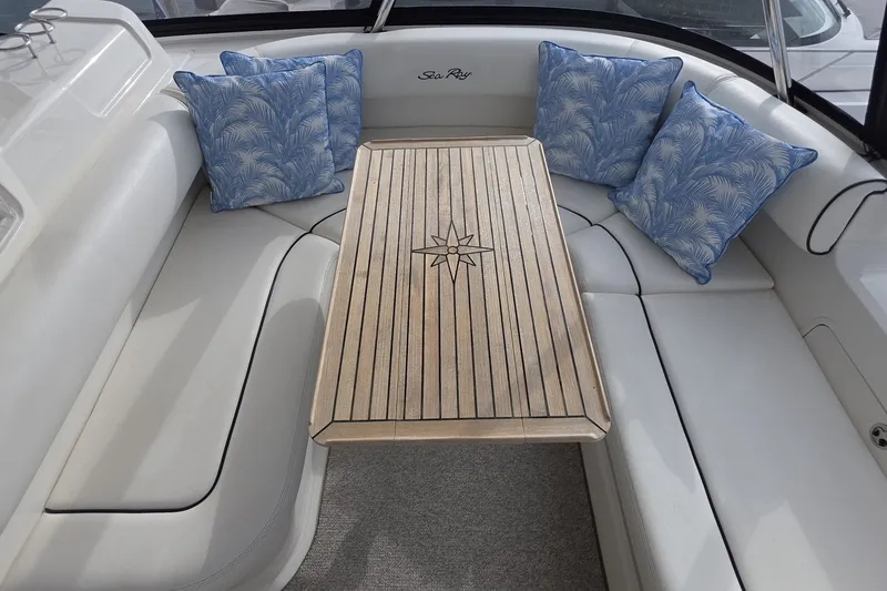 Slide: The Image of Luxurious seating area on 2005 Sea Ray 550 Sedan Bridge with blue cushions and wooden table. - 26