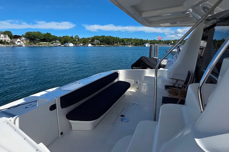 Slide: The Image of 2005 Sea Ray 550 Sedan Bridge yacht with spacious deck, overlooking serene waterfront scenery. - 62