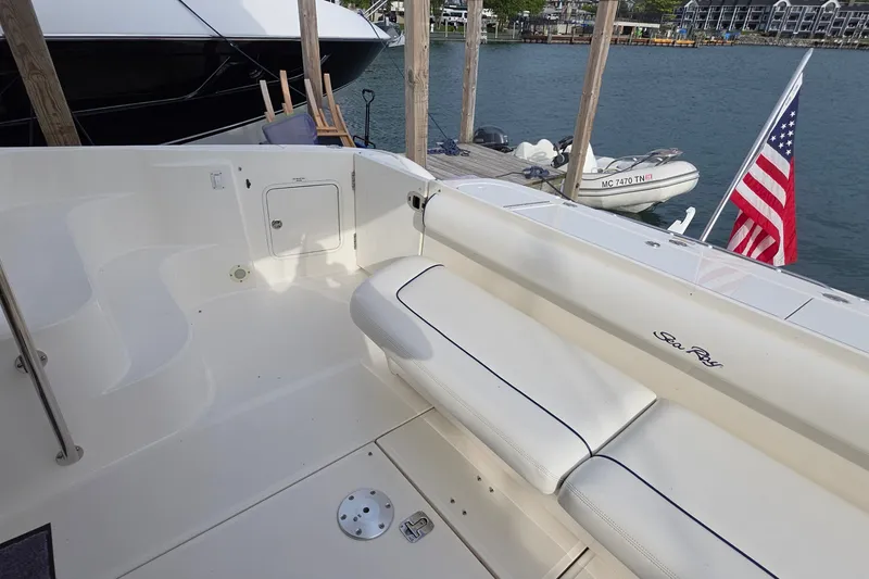 Slide: The Image of 2005 Sea Ray 550 Sedan Bridge yacht deck with seating, docked by the water. - 57