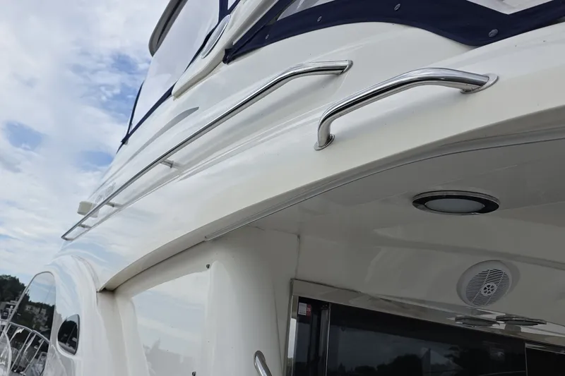Slide: The Image of 2005 Sea Ray 550 Sedan Bridge yacht exterior with chrome railings and sleek design. - 16