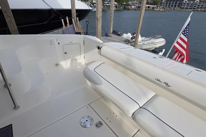 Slide: The Image of 2005 Sea Ray 550 Sedan Bridge yacht deck with seating, docked by the water. - 14