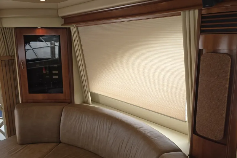 Slide: The Image of Interior of 2005 Sea Ray 550 Sedan Bridge with leather seating and wooden cabinetry. - 40