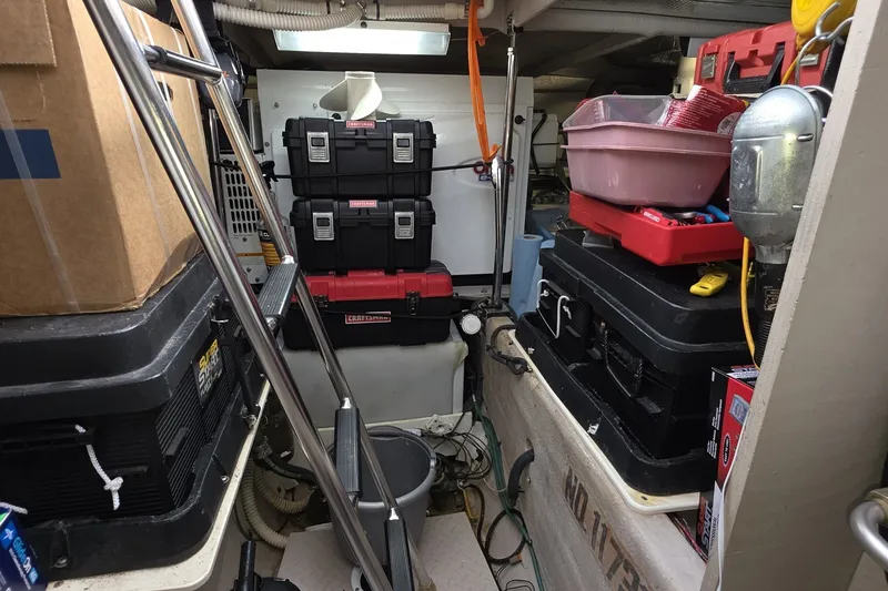 Slide: The Image of Storage area on a 2005 Sea Ray 550 Sedan Bridge, filled with toolboxes and equipment. - 75