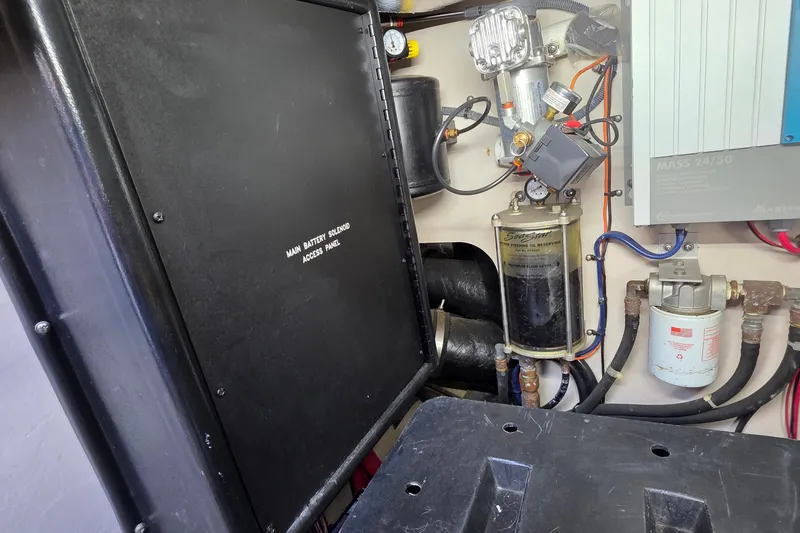 Slide: The Image of Engine room of 2005 Sea Ray 550 Sedan Bridge, featuring battery solenoid access panel and oil reservoir. - 84