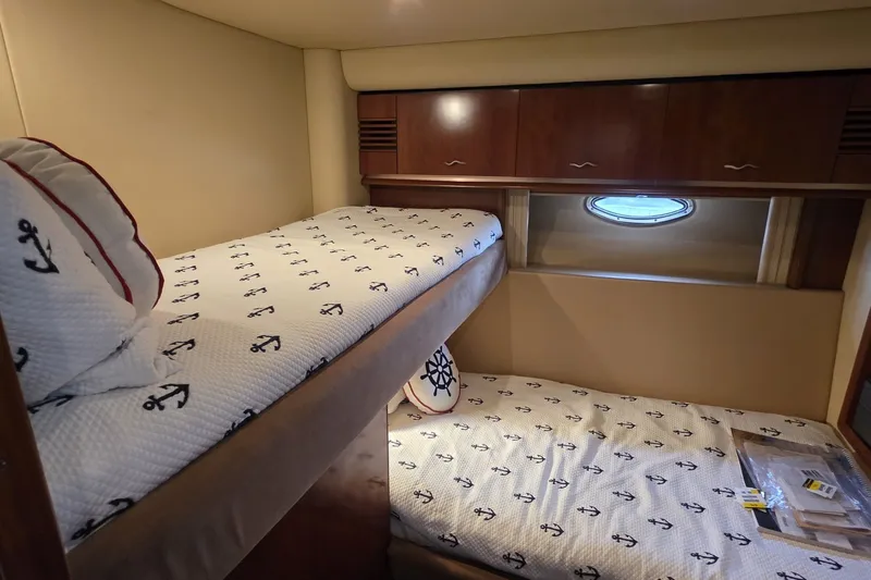 Slide: The Image of Interior cabin of 2005 Sea Ray 550 Sedan Bridge with nautical-themed bedding. - 56