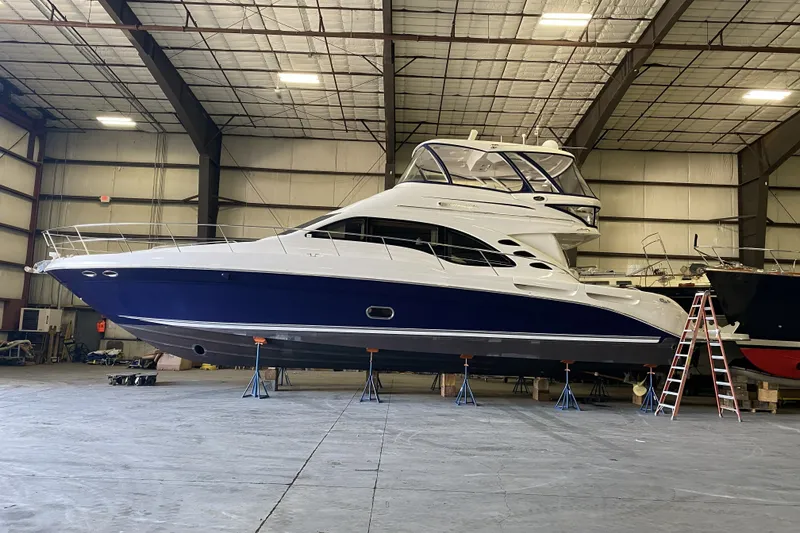 Slide: The Image of 2005 Sea Ray 550 Sedan Bridge yacht in a spacious indoor storage facility. - 3