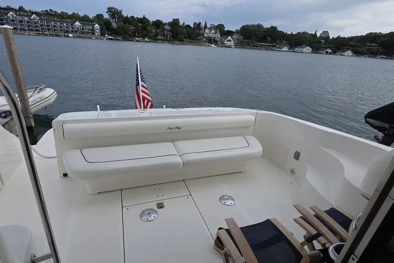 Slide: The Image of 2005 Sea Ray 550 Sedan Bridge yacht with spacious deck and seating, overlooking serene waters. - 12