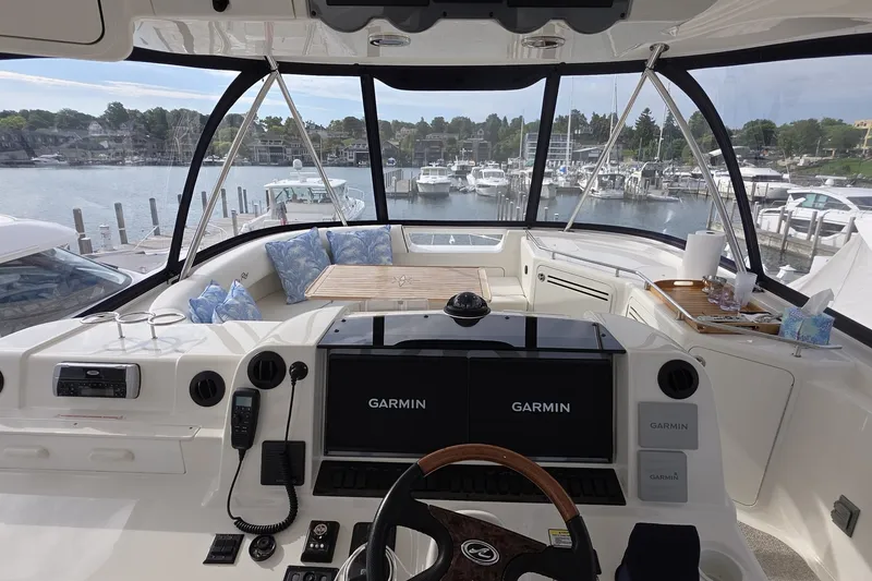 Slide: The Image of 2005 Sea Ray 550 Sedan Bridge cockpit with Garmin navigation, overlooking marina. - 21