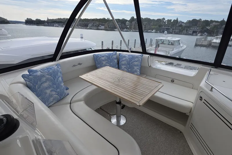 Slide: The Image of Luxurious 2005 Sea Ray 550 Sedan Bridge yacht interior with seating and table, overlooking marina. - 25