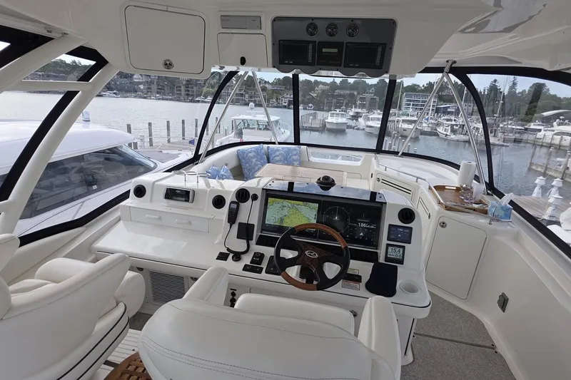 Slide: The Image of 2005 Sea Ray 550 Sedan Bridge helm with advanced navigation systems and marina view. - 23