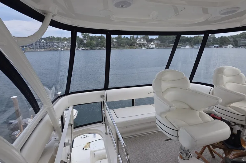 Slide: The Image of Interior view of 2005 Sea Ray 550 Sedan Bridge yacht with white seating and panoramic windows. - 22