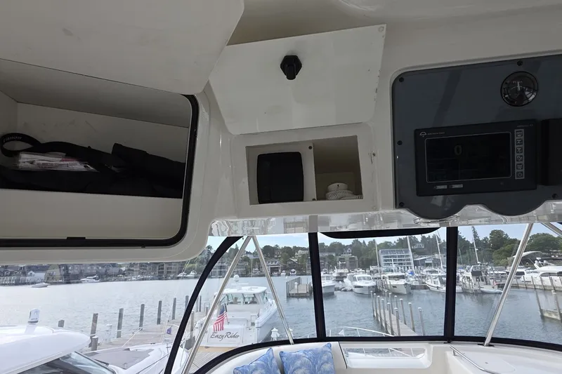 Slide: The Image of Interior view of a 2005 Sea Ray 550 Sedan Bridge yacht with storage compartments and marina backdrop. - 29