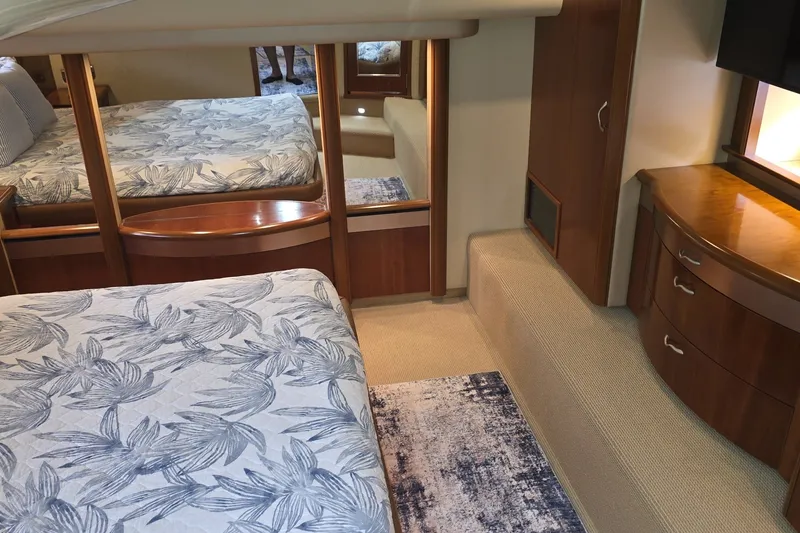 Slide: The Image of Luxurious 2005 Sea Ray 550 Sedan Bridge bedroom with elegant wood furnishings and floral bedding. - 46