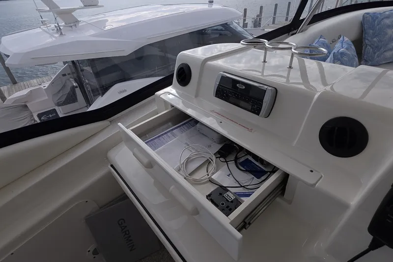 Slide: The Image of 2005 Sea Ray 550 Sedan Bridge cockpit with open storage drawer and marine electronics. - 24