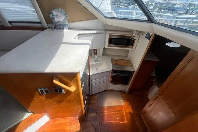 Slide: The Image of Interior of 1995 Carver 355 Aft Cabin Motor Yacht with kitchen and wooden flooring. - 16