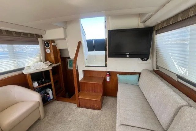Slide: The Image of Interior of 1995 Carver 355 Aft Cabin Motor Yacht with sofa, TV, and stairs. - 17
