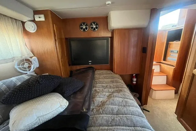 Slide: The Image of Interior of 1995 Carver 355 Aft Cabin Motor Yacht with cozy bed and TV. - 24