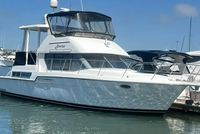 The Image of 1995 Carver 355 Aft Cabin Motor Yacht docked in a marina under clear skies. - 0