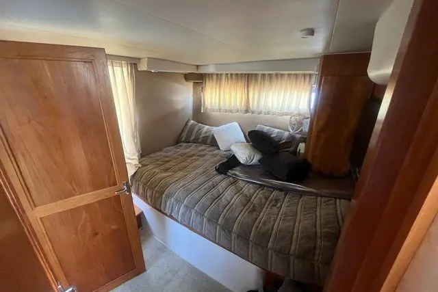 Slide: The Image of Cozy bedroom in 1995 Carver 355 Aft Cabin Motor Yacht with plush bedding and wooden accents. - 18