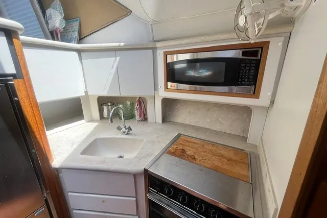 Slide: The Image of 1995 Carver 355 Aft Cabin Motor Yacht kitchen with sink, stove, and microwave. - 22