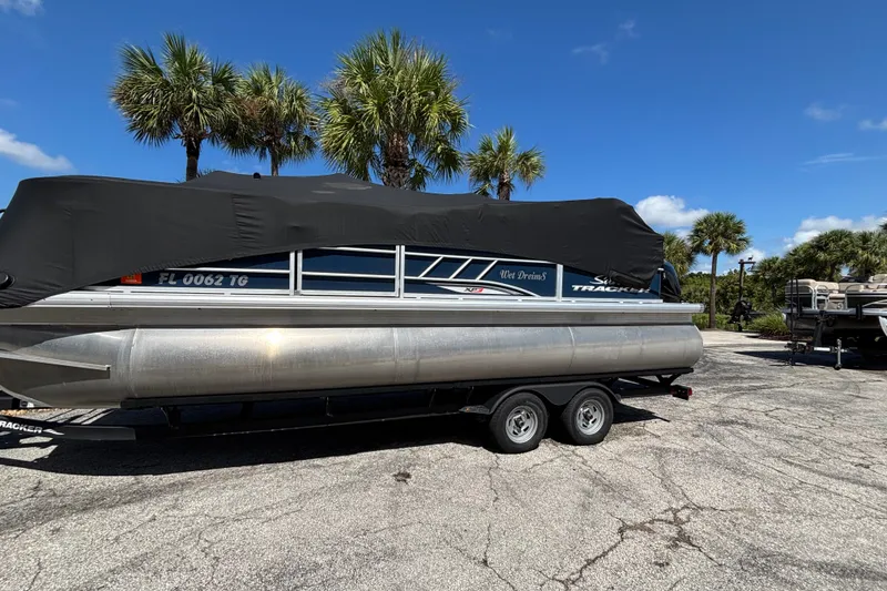 The Image of 2022 Sun Tracker Party Barge 22 RF XP3 pontoon boat covered, parked near palm trees. - 0