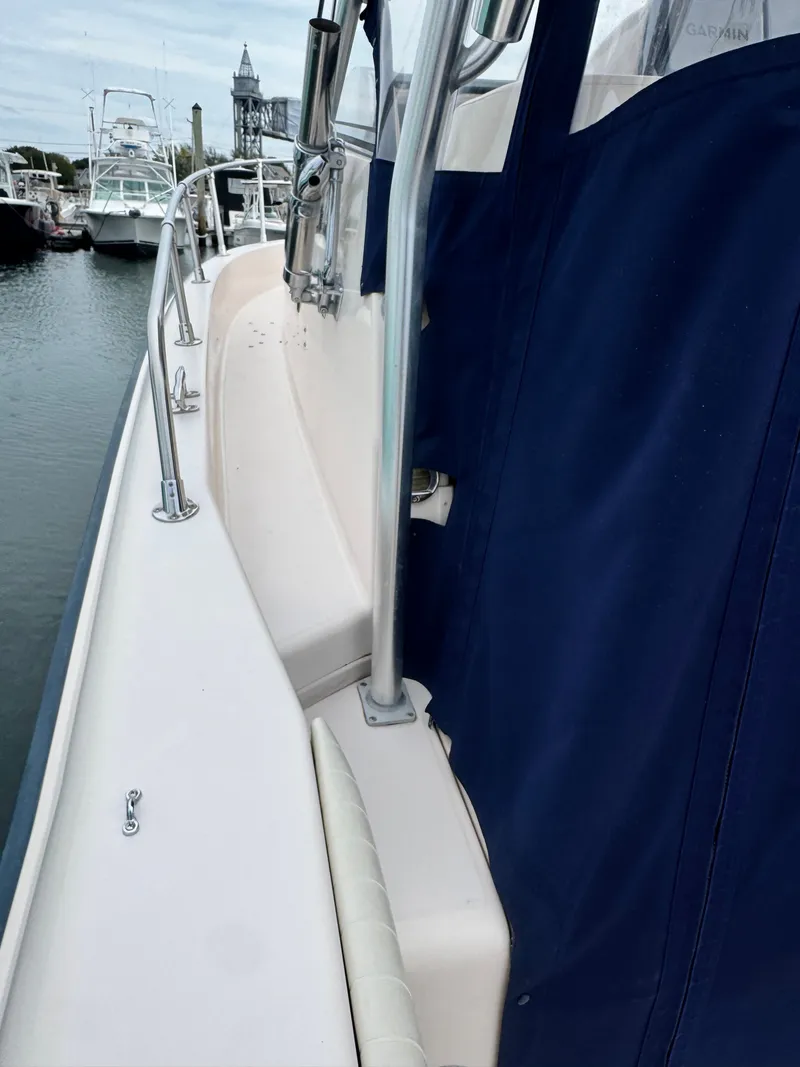 Slide: The Image of Side view of a Grady-White Sailfish 282 with blue cover in a marina. - 11