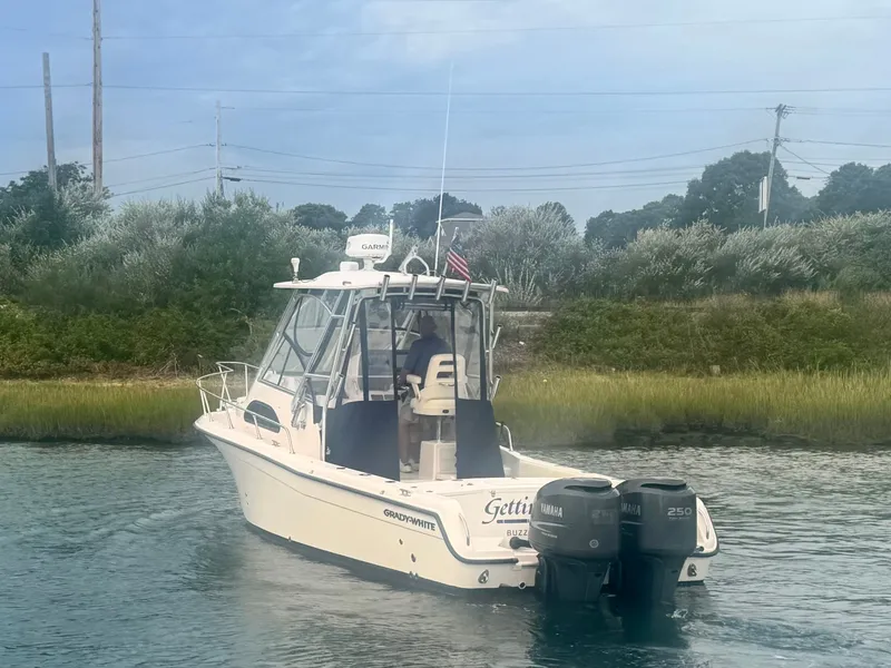 Slide: The Image of A 2006 Grady-White Sailfish 282 on calm water. It features twin outboard engines. - 7