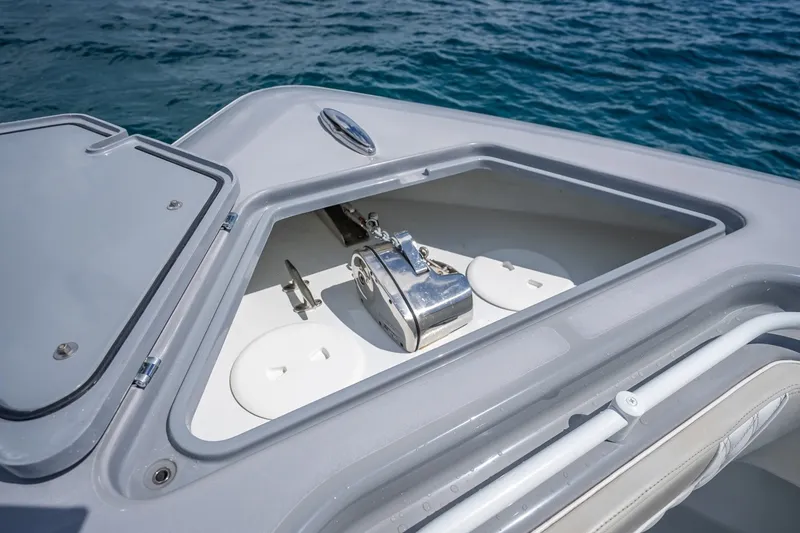 Slide: The Image of 2024 Contender 44 ST boat anchor compartment with open hatch, on calm blue water. - 38