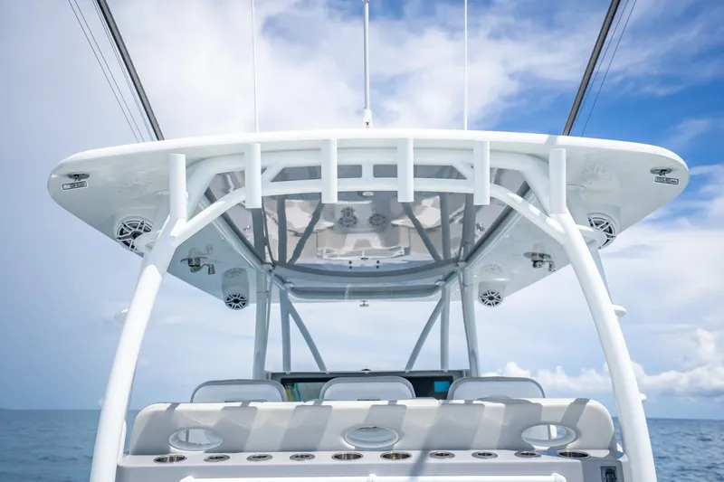 Slide: The Image of 2024 Contender 44 ST boat helm with T-top against a clear blue sky. - 19