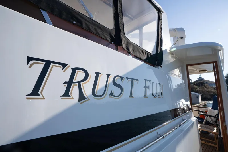 Slide: The Image of 1991 Lien Hwa Cockpit Sundeck yacht with "Trust Fun" name, docked in sunlight. - 55