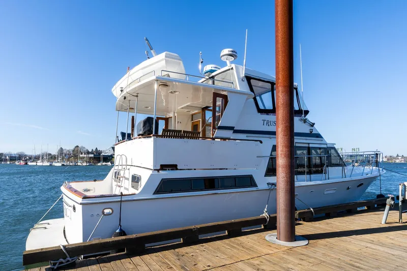 The Image of 1991 Lien Hwa Cockpit Sundeck yacht docked at a marina under clear blue skies. - 1