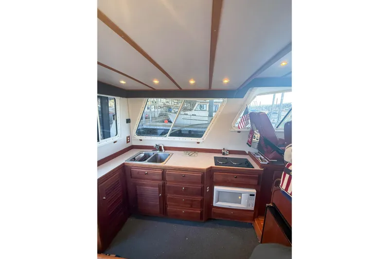 Slide: The Image of Interior of 2003 SeaSport Pacific 3200 boat with kitchen area and wooden cabinetry. - 10