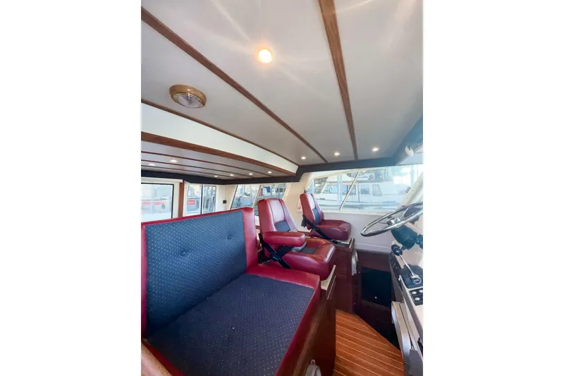 Slide: The Image of Interior of 2003 SeaSport Pacific 3200 boat with red seating and wooden accents. - 17