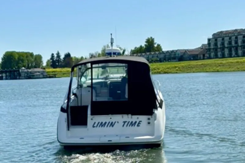 Slide: The Image of 1992 Tiara 270 Sport boat named "Limin' Time" on a calm river. - 1